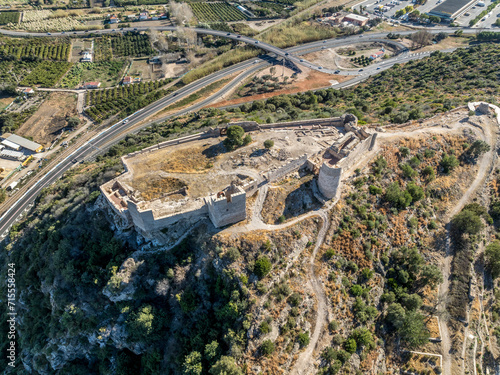 Aerial view of Bairen medieval castle ruin near Gandia in Spain with partially restored circular towers with cloudy sky