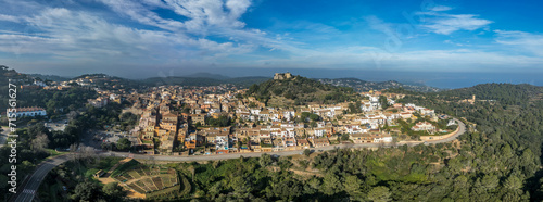 Aerial view of 16th-century Begur castle fort atop a forested hill, with panoramic views of the Mediterranean Sea. Watch towers built against the pirates photo