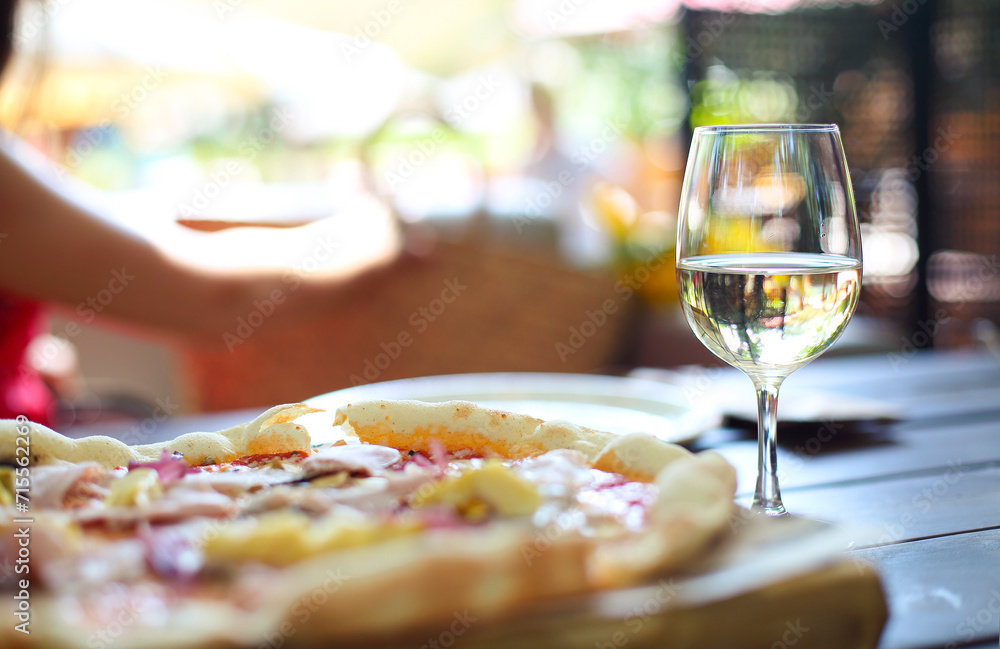 Pizza and white wine in outdoor restaurant.