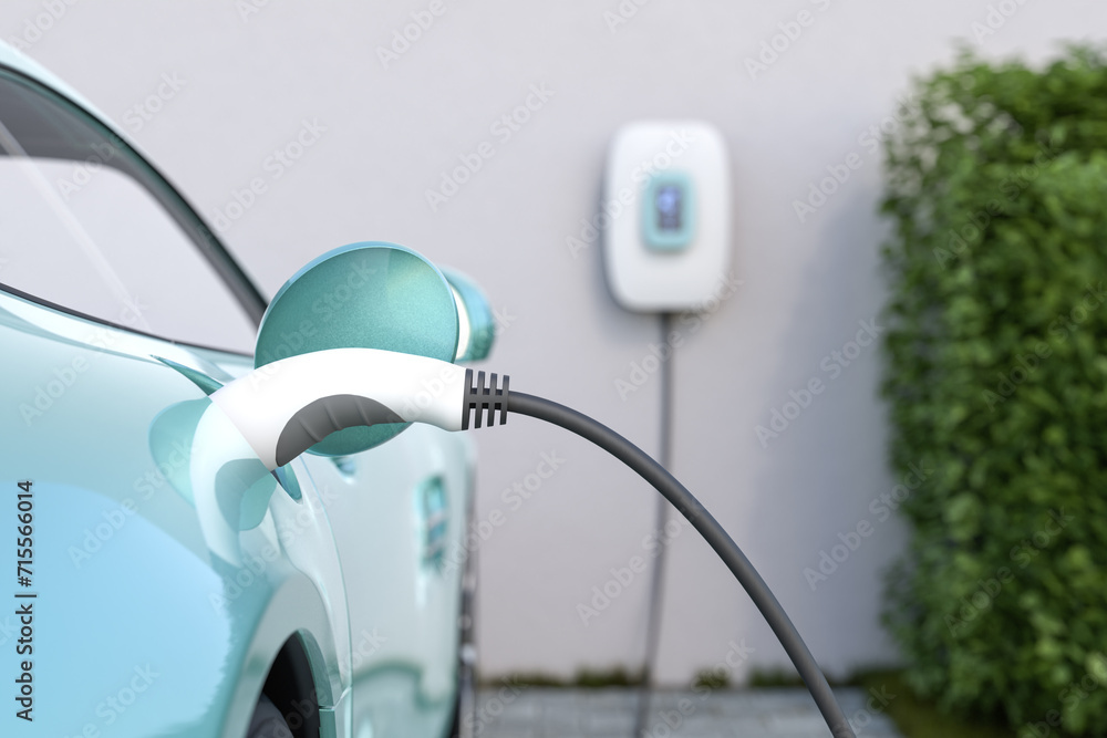 Charging an electric vehicle at home with a home charging station (wallbox). Focus on the plug in the car. Selective focus.