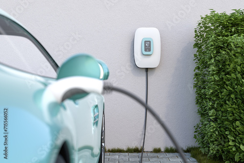 Charging an electric vehicle at home with a home charging station (wallbox). Focus on the wallbox displaying status information. Selective focus. photo