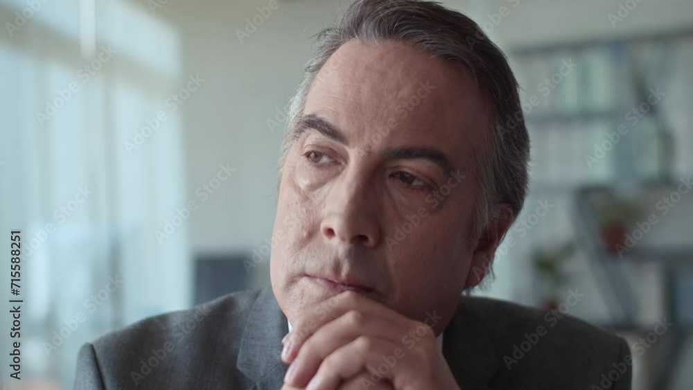 Close up of pensive senior male entrepreneur thinking about something while staying in office Close up of pensive senior male entrepreneur thinking about something while staying in office