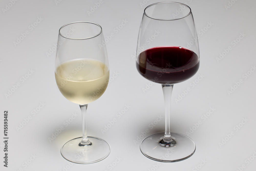 a glass of red wine and a glass of white wine on a table. a glass of red wine and a glass of white wine on a table.