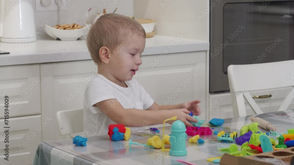 3-year-old child cute little boy using play dough making diverse shapes have fun at home 3-year-old child cute little boy using play dough making diverse shapes have fun at home