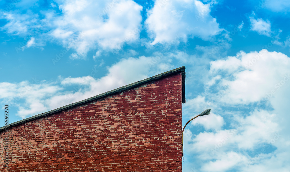 fragment of a brick building with a lantern against a blue sky w