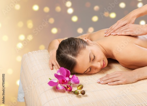 Woman enjoying body massage at spa salon.