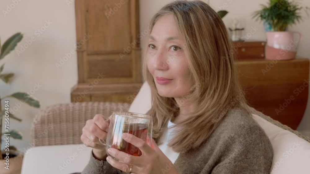 Asian woman spending great time at home drinking coffee, hot chocolate, tea, listening to music, communicating with family. Lifestyle concept Asian woman spending great time at home drinking coffee, hot chocolate, tea, listening to music, communicating with family. Lifestyle concept