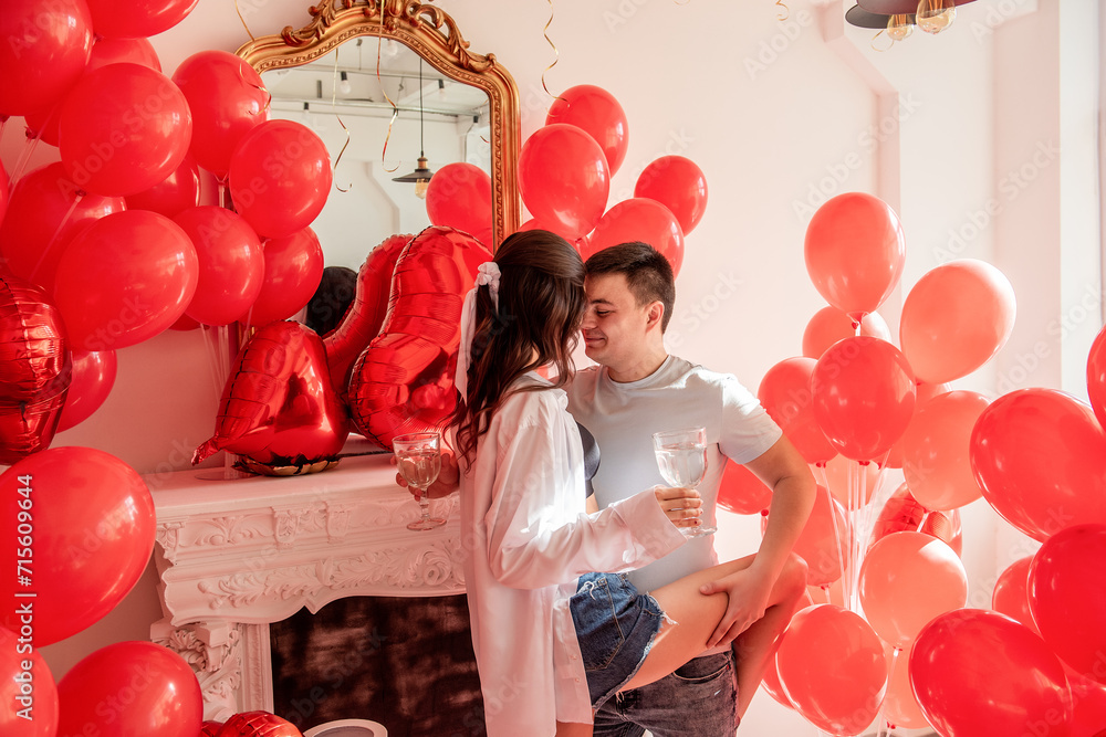 Joyous moment between dancing young couple celebrating with toast Valentines day near red