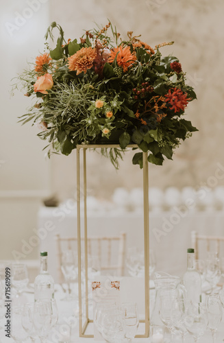 Wedding centrepiece with autumn flowers on a gold stand