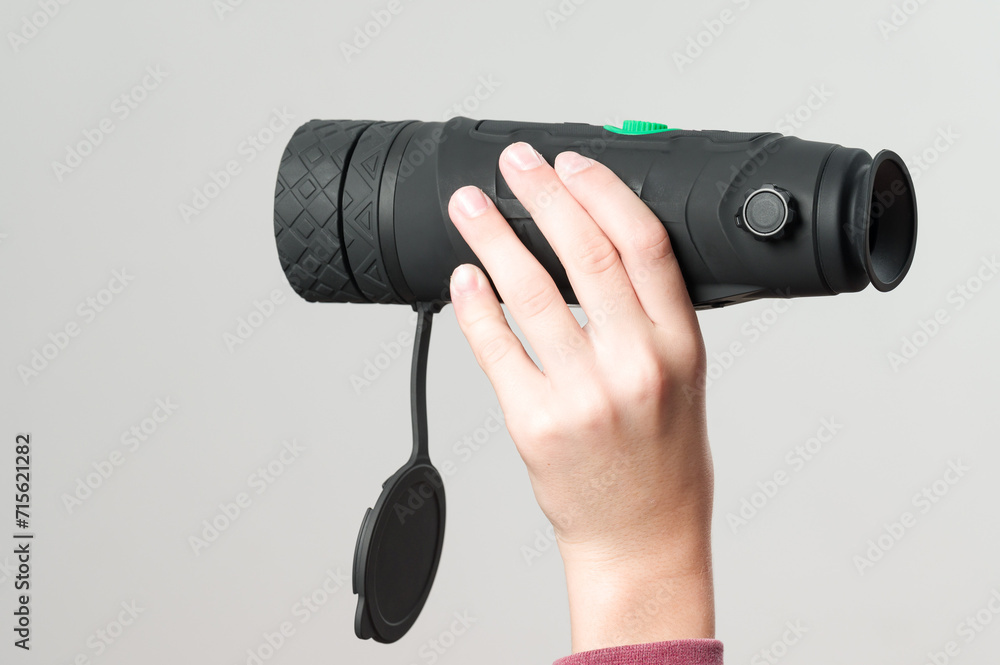 A child holds a monocular in his hand on a white background. A child holds a monocular in his hand on a white background.