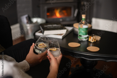 anonymous couple drinking gin in front of a fire photo