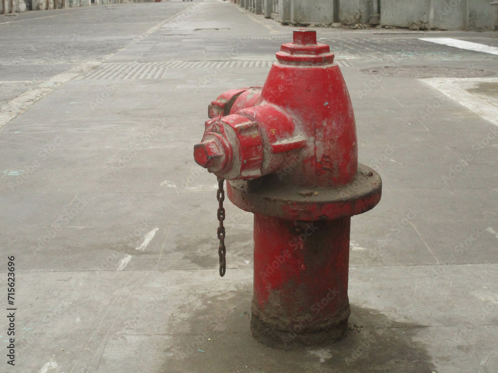 Hidrante rojo en esquina de una calle. Toma de agua para bomberos.
Hidrante rojo en esquina de una calle. Toma de agua para bomberos.