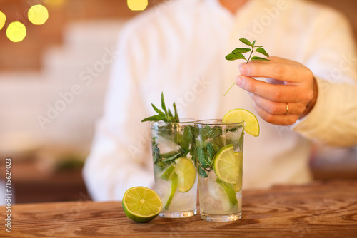 Bartender making two mojito cocktails