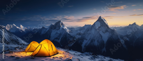 Panorama of Steep peak mountains with covered snow and yellow tent camping at twilight time. © Santy Hong