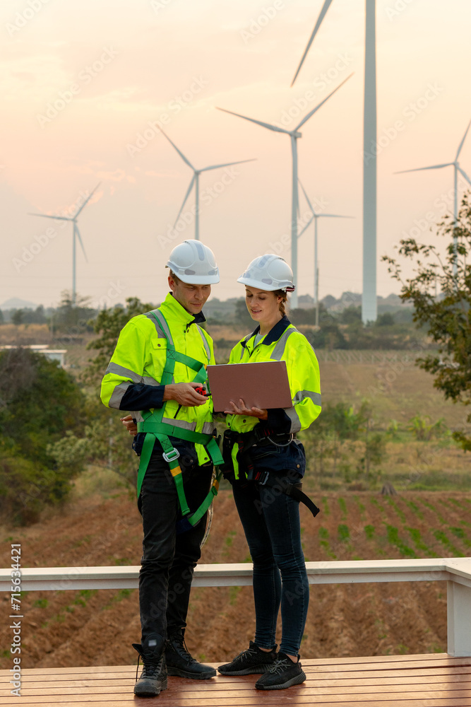 custom made wallpaper toronto digitalVertical image professional technician workers stand together in front of windmill or wind turbine using laptop to discuss about work with evening light.