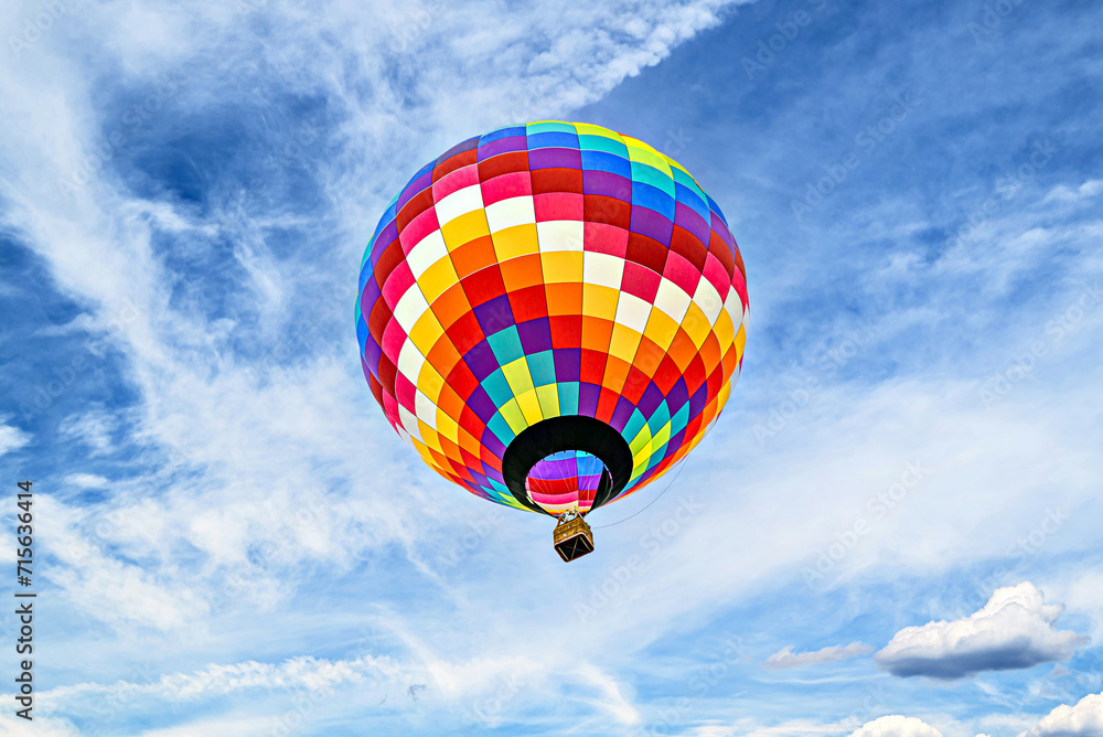 Fototapeta premium Colorful hot air balloon flying over blue sky with white clouds