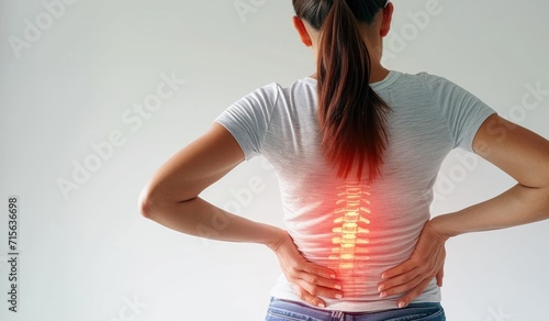 Woman touching painful back suffering from spine pain due to osteoposis, degeneration, cancer or disc disease. Healthcare and health insurance concept. photo