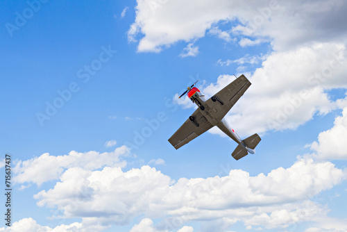 View of an aerobatic plane (aerodyne), in flight under a blue sky with white clouds. flight exhibitions	 photo