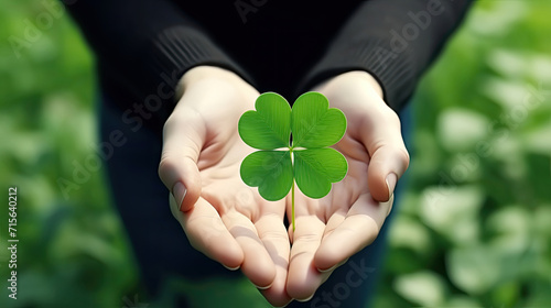 Earth Day, Woman's Day, Female Hand Holding Green Sprout Clover Leaf on Nature Background