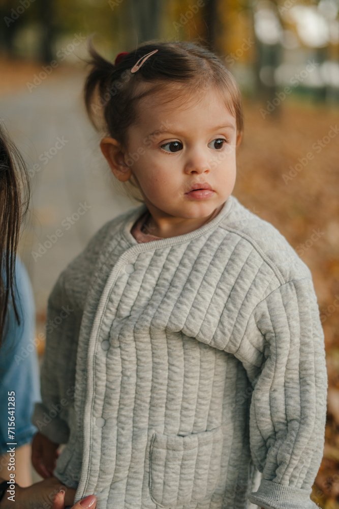 Autumn outdoor portrait of beautiful happy girl looking away. Your kid walking in park or forest outdoors, spring.