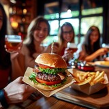 Generative AI image of Man holding a burger in his hands sitting in a restaurant, four women are looking at the man as he eats the burger and want this burger too