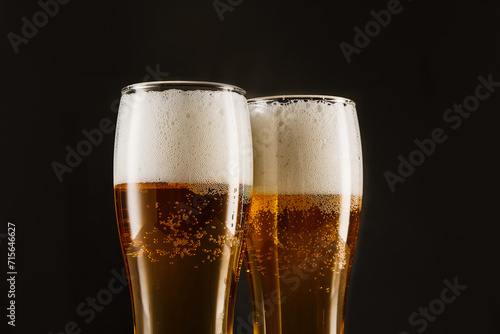 Golden brew with foam, bubbles filling tall glasses.