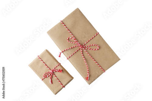Two Christmas and New Year gift boxes wrapped in brown craft kraft paper with red and white baker's twine, ribbon bow isolated on white, transparent background, PNG
