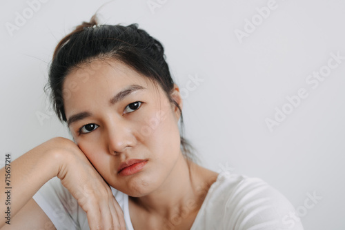Asian Thai woman take selfie with bored face, unhappy boring time, resting her head on one hand, isolated over white background wall. 