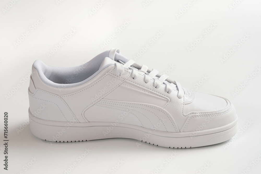 White sports shoes on a gray background close-up. White sports shoes on a gray background close-up.