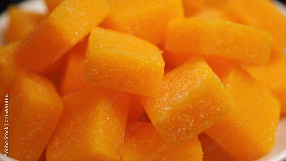 Dried and candied mango cubes background. Vegetarian food concept. Dried and candied mango cubes background. Vegetarian food concept.