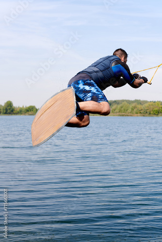 a male wakeboarder starts with his back in a jump