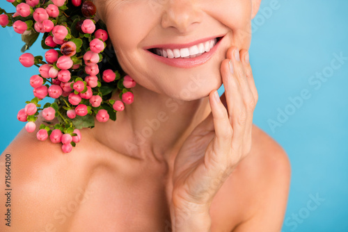 Cropped photo of positive sweet elderly lady naked shoulders enjoying flowers aroma tooth paste isolated blue color background