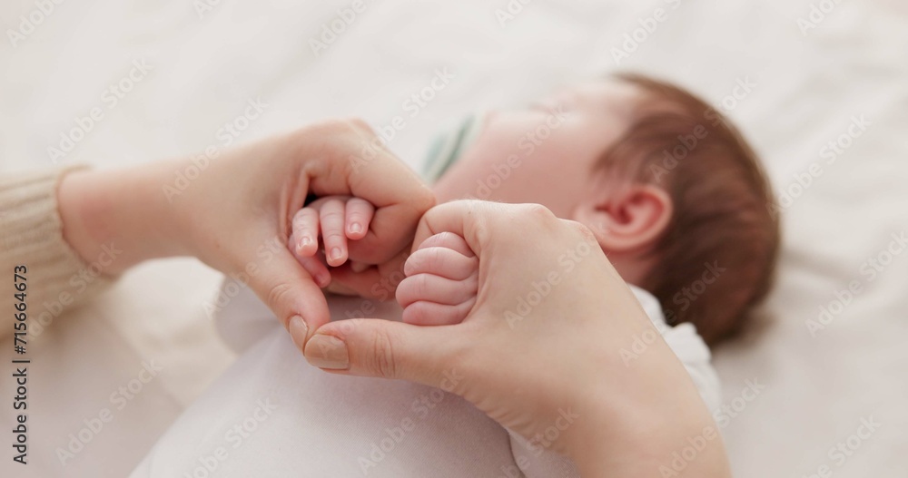 Bed, holding hands and mother with baby, love and support for care, health and wellness at home. Fingers, family or mama with a healthy infant, protection and child development with bond or maternity Bed, holding hands and mother with baby, love and support for care, health and wellness at home. Fingers, family or mama with a healthy infant, protection and child development with bond or maternity