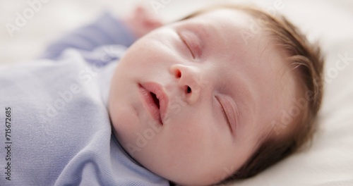 Face, relax and sleep with a baby on a bed closeup in a home, dreaming during a nap for child development. Growth, calm and rest with an adorable newborn infant asleep in a bedroom for comfort