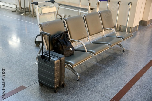 空港内のベンチに置かれたキャリーバッグ