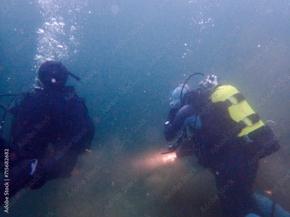 Scuba divers in a merky lake in Switzerland Scuba divers in a merky lake in Switzerland