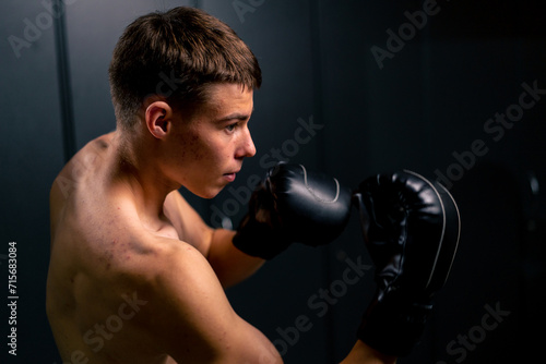 portrait of a young boy boxer in boxing gloves practicing his punches in the gym before training © Guys Who Shoot