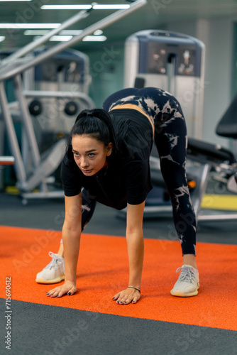 a young girl in sportswear in the gym does stretching exercises before the start of training