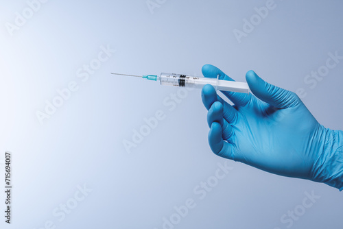Doctor in blue latex gloves with syringe. Vaccination, immunization, treatment to Covid 19 Corona Virus infection. Healthcare And Medical concept.