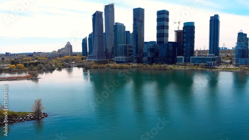 Business district's towers line calm lake shores. serene lake reflects city's bustling business skyline. perfect business harmony between urban landscape, tranquil nature commercial vigor. Drone view.