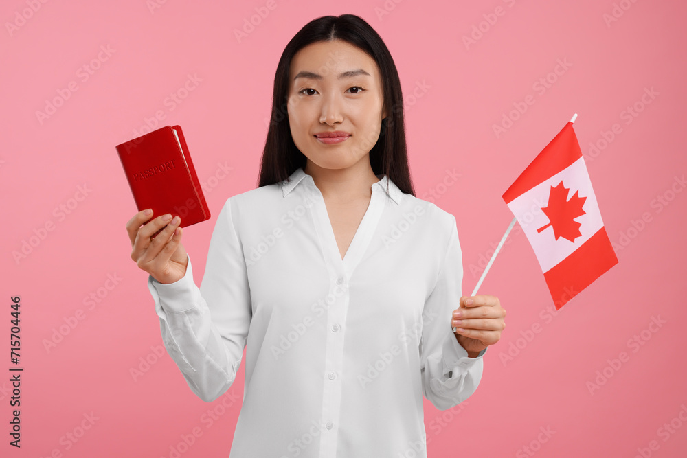 Immigration to Canada. Woman with passport and flag on pink background Immigration to Canada. Woman with passport and flag on pink background