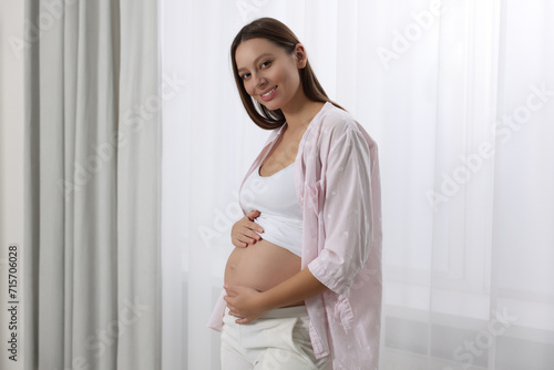 Beautiful pregnant woman in pink shirt near window indoors Free Download Beautiful pregnant woman in pink shirt near window indoors - GFXLoad