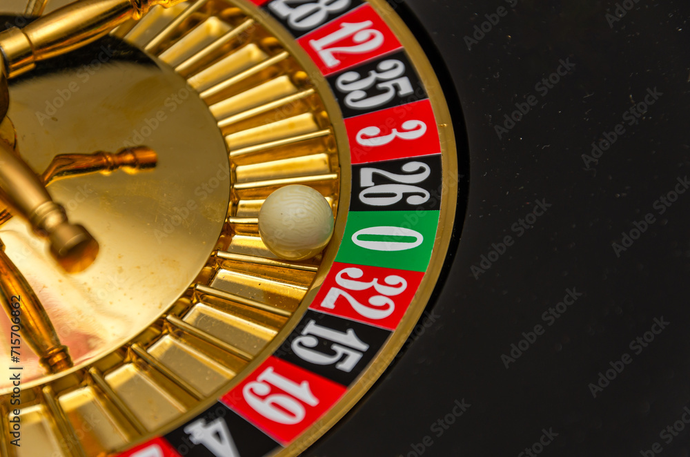Casino roulette wheel with ball and numbers on a dark background, close-up Casino roulette wheel with ball and numbers on a dark background, close-up