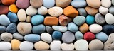 Close up of vibrant, smooth beach pebbles showcasing their textures and hues under radiant sunlight