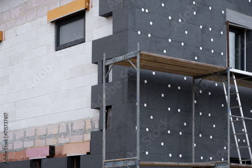 modern thermal insulation materials. building New House in process insulation of the wall of the house with layers Exterior covering in construction site.