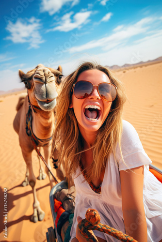 Happy female tourist having fun enjoying group camel ride tour in the desert. © wolfhound911