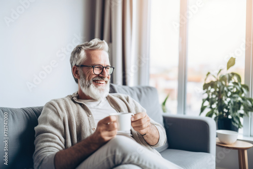 Man drinking coffee sitting on sofa at home © wolfhound911
