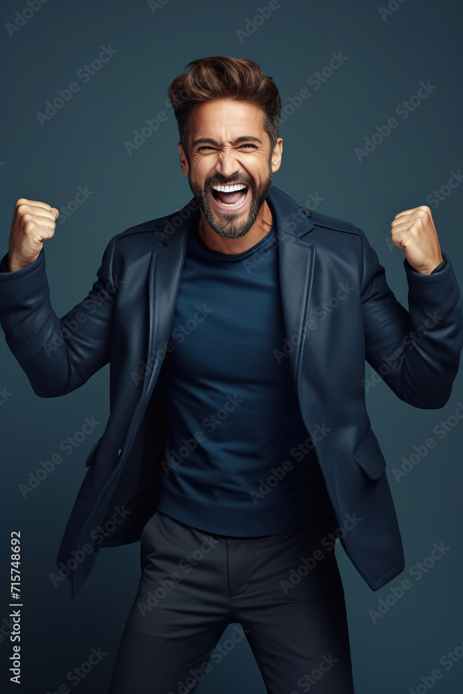 Cheerful man dressed stylish clothes celebrate success raise hands fists isolated on dark blue color background