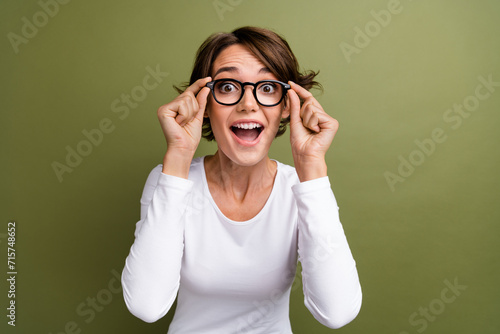 Photo portrait of lovely young lady touch specs excited manager wear trendy white garment isolated on khaki color background