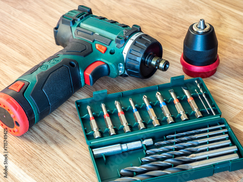 Cordless drill driver with screw bits and drill bits. Tool free changeover between drilling and screwdriving. Removable keyless chuck with quick release integrated magnetic bit holder in the spindle  photo
